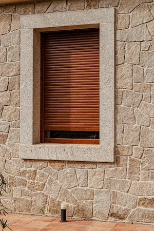 Chapado rústico y ventana en granito rubio con acabado abujardado grueso.