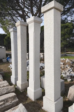 Columnas cuadradas de granito en tres piezas con biseles en base, fuste y capitel, artesanía detallada.