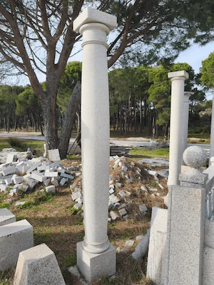 Columna torneada en granito blanco cristal con acabado aserrado, detalle arquitectónico refinado.