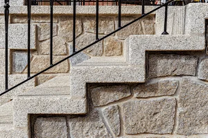 Combinación de acabados texturizados en granito rubio para escaleras.