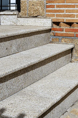 Escalera en granito rubio abujardado.