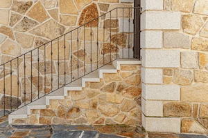 Esquinón y peldaños macizos en forma de L de granito blanco cristal abujardado.