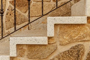 Detalle de peldaño en forma de L en granito blanco cristal abujardado.