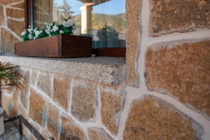 Vierteaguas en granito rubio con acabado abujardado grueso, protección eficaz para ventanas.